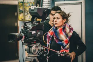Behind the scene. Cameraman and assistant shooting film with camera